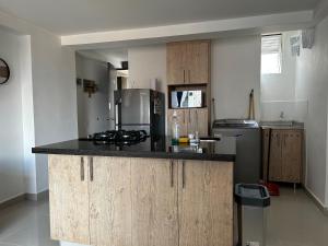 a kitchen with a counter top and a refrigerator at Hermoso loft en medellin in Medellín