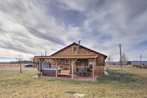 a log cabin with a bed and chairs in a field at Secluded Cabin with Hot Tub, Game Room and Views! in Durango