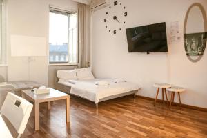 ein Wohnzimmer mit einem Sofa und einem TV an der Wand in der Unterkunft Joyful 2BR Apt. @ Millenium Tower and The Danube in Wien