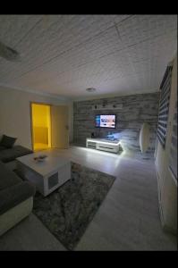 sala de estar con sofá y TV en la pared en Apartment Center 23, en Podgorica