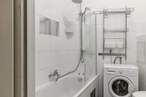 a bathroom with a washing machine and a shower at Joyful 2BR Apt. @ Millenium Tower and The Danube in Vienna