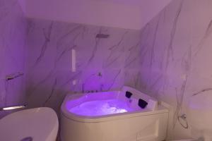 un bagno viola con servizi igienici e vasca di MY BRILLIANT HOME WITH JACUZZI 2 STEPS FROM St TOLEDO a Napoli Altre 52 foto