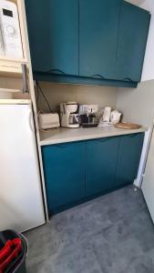 a kitchen with blue cabinets and a counter top at Appartements Bozeman in La Mongie