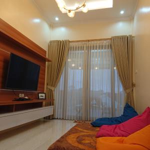 a living room with a large window with a flat screen tv at Sapphire Village Guesthouse in Rempawah