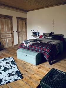 a bedroom with a bed and a wooden floor at L'instant présent in Echallon