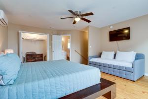 a bedroom with a blue bed and a blue couch at Walkable Downtown Apt with Game Room! in Mobile