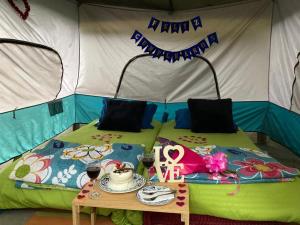 a bed in a tent with a table in front of it at Glamping Laguna Sagrada in Bobadilla
