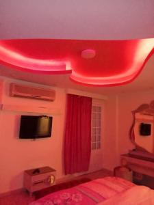 a bedroom with a red light on the ceiling at شقق فاخرة للايجار مفروش مصر الجديدة مساكن الشيراتون in Cairo