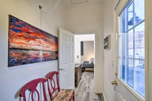 a red chair in a hallway with a painting on the wall at Stylish Klamath Falls Unit Less Than half Mi to OIT! in Klamath Falls