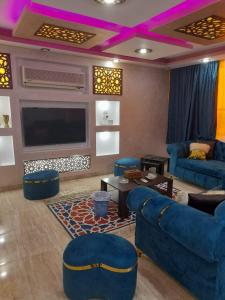 a living room with blue furniture and a flat screen tv at شقق فاخرة للايجار مفروش مصر الجديدة مساكن الشيراتون in Cairo