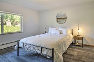 1 dormitorio con 1 cama grande y espejo en Lakefront Seattle Area House with Private Deck! en Lynnwood