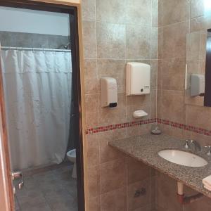 a bathroom with a sink and a shower at Hostal Tierra del Sol in Salta