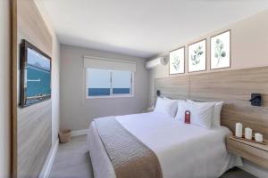 a bedroom with a large white bed and a window at Nobile Hotel Montoya in Punta del Este