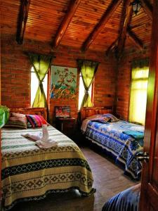 1 Schlafzimmer mit 2 Betten in einer Holzhütte in der Unterkunft Cabaña Puñushiki kalera Lodge 