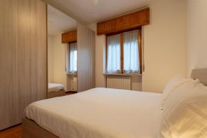 - une chambre avec un lit blanc et 2 fenêtres dans l'établissement Casa di Emma - Verona, Lago di Garda, Valpolicella, à Negrar