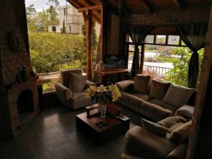 ein Wohnzimmer mit Sofas und einem Tisch mit Blumen in der Unterkunft Cabaña Puñushiki kalera Lodge 