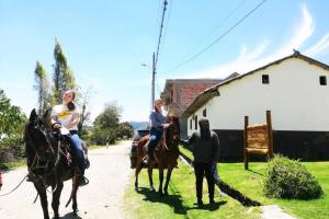 a couple of people riding horses on a street at Cabaña Puñushiki kalera Lodge 