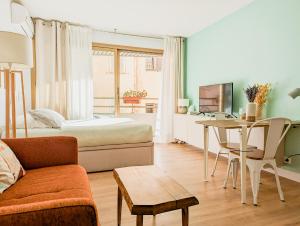 Cette chambre comprend un lit, une table et un canapé. dans l'établissement Les Beaux Jours - Calm & Sunny balcony, à Antibes