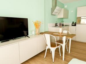 une cuisine avec une table et des chaises ainsi qu'une télévision dans l'établissement Les Beaux Jours - Calm & Sunny balcony, à Antibes