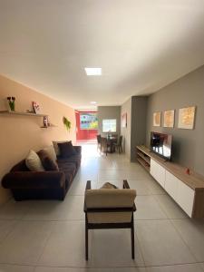 uma grande sala de estar com um sofá e uma mesa em Dois quartos com varanda - super espaçoso em Barra do Piraí