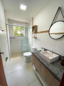 uma casa de banho com um lavatório, um chuveiro e um WC. em Dois quartos com varanda - super espaçoso em Barra do Piraí