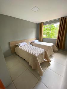 um quarto com 2 camas e uma janela em Dois quartos com varanda - super espaçoso em Barra do Piraí