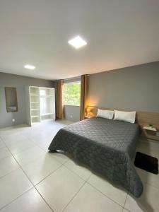 um quarto com uma cama grande num quarto em Dois quartos com varanda - super espaçoso em Barra do Piraí