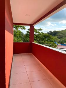 uma varanda de uma casa com paredes vermelhas em Dois quartos com varanda - super espaçoso em Barra do Piraí