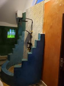 a stairway in a room with a blue wall at Sagando Bungalows Zanzibar in Michamvi