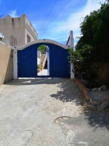 un garaje azul con un arco en un edificio en Maison à El Omrane ., en Túnez