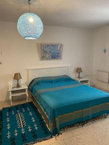 a bedroom with a bed and two tables with lamps at Maison à El Omrane . in Tunis