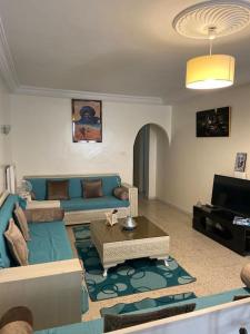 a living room with a blue couch and a tv at Maison à El Omrane . in Tunis