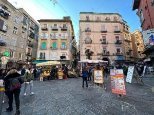 Un gruppo di persone che camminano per un mercato in una città di MY BRILLIANT HOME WITH JACUZZI 2 STEPS FROM St TOLEDO a Napoli