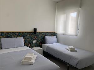 two beds sitting next to each other in a room at Apartamento junto a Estación Ave · 3 dormitorios in Granada