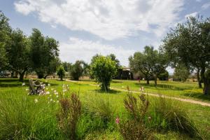 a park with trees and grass and flowers at Agriturismo La Facenda in Albinia