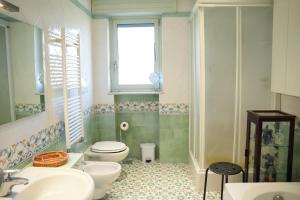 a bathroom with a toilet and two sinks and a window at La casa nel Parco**** in Torre Annunziata +16 photos