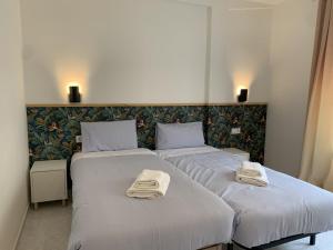 two beds in a hotel room with towels on them at Apartamento junto a Estación Ave · 3 dormitorios in Granada