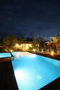 una grande piscina notturna con luci di Bida Daree Resort ad Aonang Beach