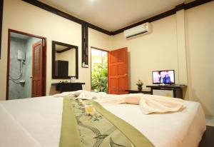 a bedroom with a bed and a tv in a room at Bida Daree Resort in Ao Nang Beach