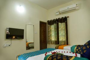 a hotel room with two beds and a tv at Kumbakonam Inn Hotels - Kumbakonam Inn Stay in Kumbakonam