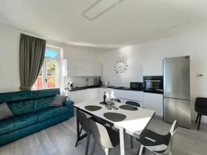 a kitchen and living room with a table and a blue couch at Belvedere 229 Lakeview Apartment in Ghiffa