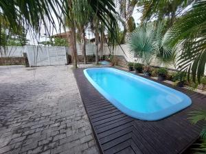 duży niebieski basen na ceglanym patio w obiekcie Loft Barra da Fortaleza com Piscina w mieście Florianópolis