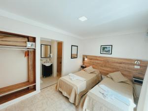 a hotel room with two beds and a bathroom at Hotel Monet in Mar del Plata