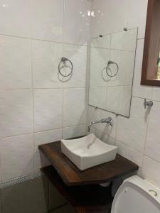 a bathroom with a sink and a mirror and a toilet at Varandas da Serra / Reserva Alto da Colina in Conceição da Ibitipoca +24 photos