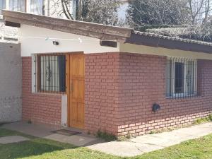 a brick house with a wooden door on it at Mono Belgrano1 in San Carlos de Bariloche