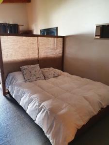 a large bed in a bedroom with a large headboard at Mono Belgrano1 in San Carlos de Bariloche +3 photos