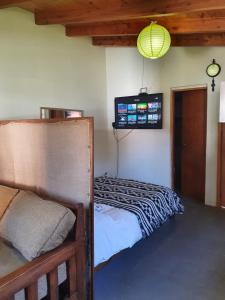 um quarto com uma cama e uma televisão na parede em Mono Belgrano1 em San Carlos de Bariloche