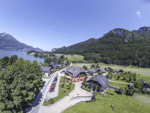 - une vue aérienne sur un complexe avec un lac et des montagnes dans l'établissement Landgasthof Leopoldhof, à Sankt Wolfgang im Salzkammergut