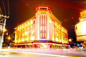a large white building with a clock tower at night at Dong Khanh Hotel in Ho Chi Minh City