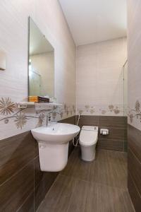 a bathroom with a sink and a toilet and a mirror at Minh Phước Villa 12 Kim Ngân in Vung Tau